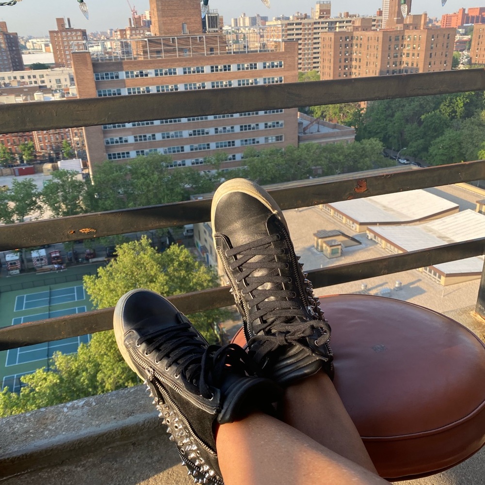 Studded black leather sneaker. Zipper detail.